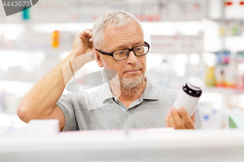 Image of senior male customer with drug at pharmacy