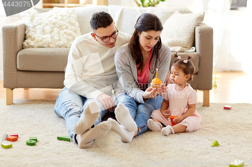 Image of baby girl with parents at home birthday party