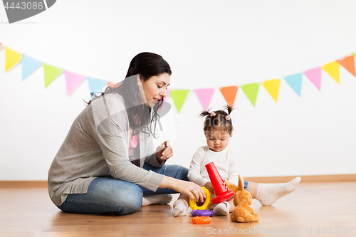 Image of mother and baby daughter playing with pyramid toy