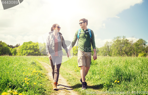Image of happy couple with backpacks hiking outdoors