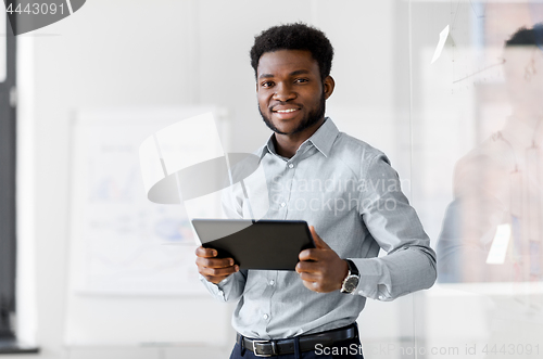 Image of smiling businessman with tablet pc at office