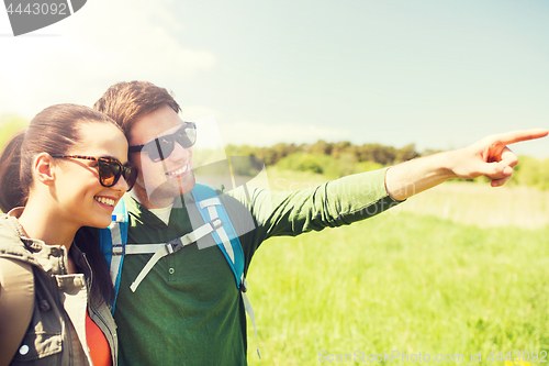 Image of happy couple with backpacks hiking outdoors