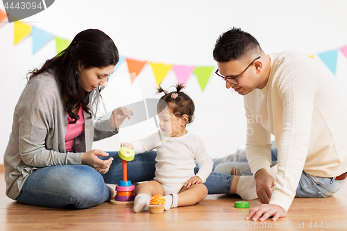 Image of baby girl with parents playing with pyramid toy