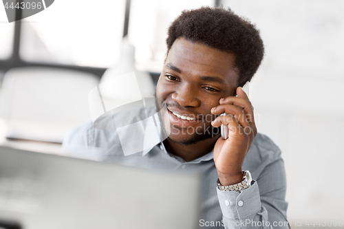 Image of businessman calling on smartphone at office