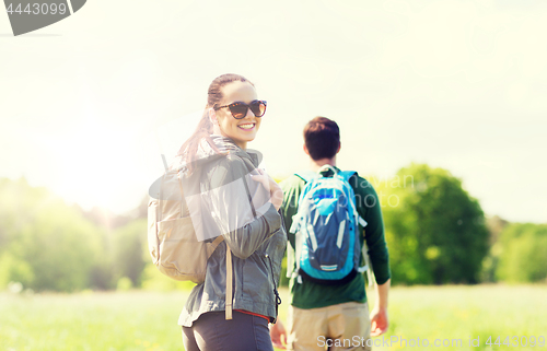 Image of happy couple with backpacks hiking outdoors