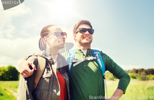 Image of happy couple with backpacks hiking outdoors