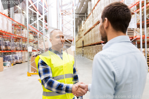 Image of worker and businessman with clipboard at warehouse