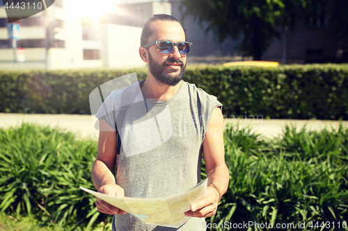 Image of man traveling with backpack and map in city