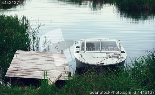 Image of Motorboat At The Pier Among The reeds In A River Bay