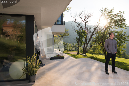 Image of man in front of his luxury home villa