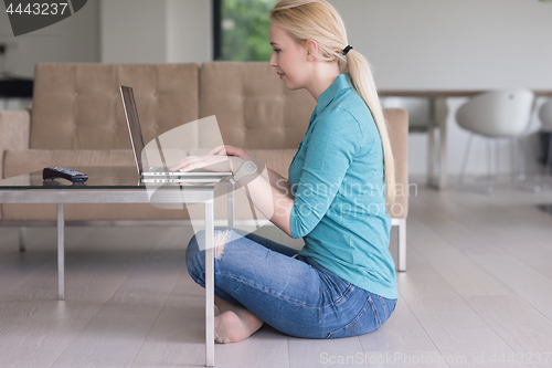 Image of young women using laptop computer on the floor