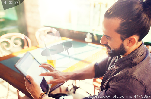 Image of man with tablet pc drinking beer at bar or pub