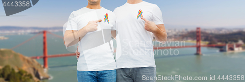 Image of close up of couple with gay pride rainbow ribbons