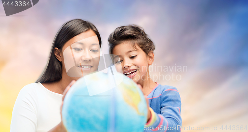 Image of happy mother and daughter with globe over sky