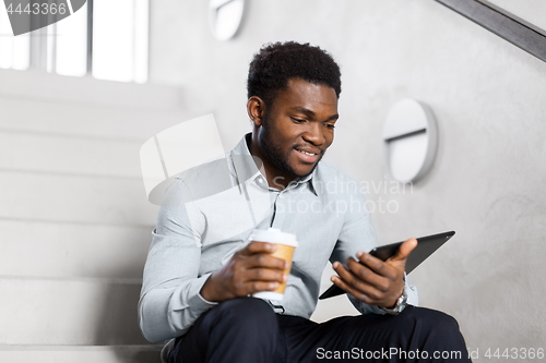 Image of businessman with tablet pc and coffee on stairs