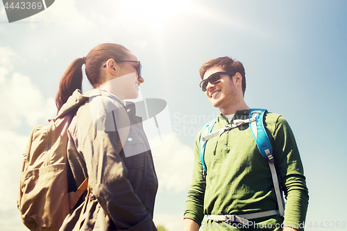 Image of happy couple with backpacks hiking outdoors