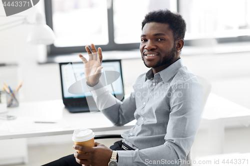 Image of african american businessman with coffee at office