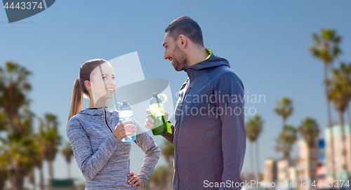 Image of couple of sportsmen with water over venice beach