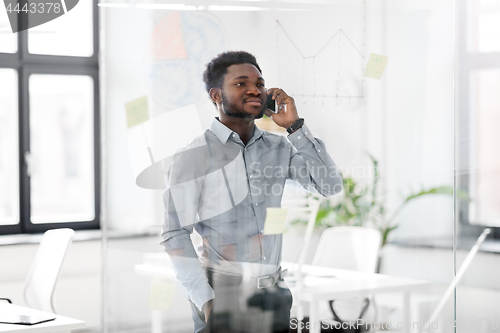 Image of businessman calling on smartphone at office