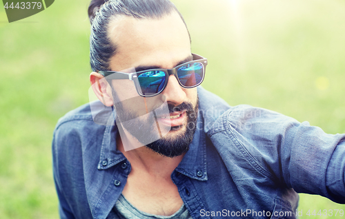 Image of man in sunglasses at city street or park