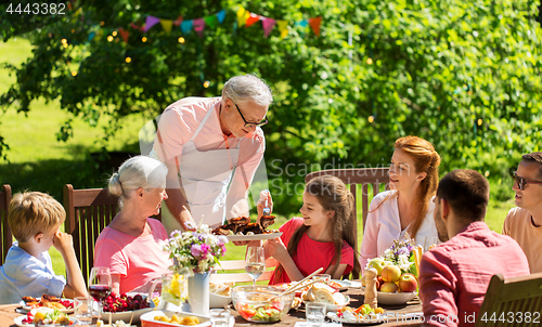 Image of happy family having dinner or summer garden party