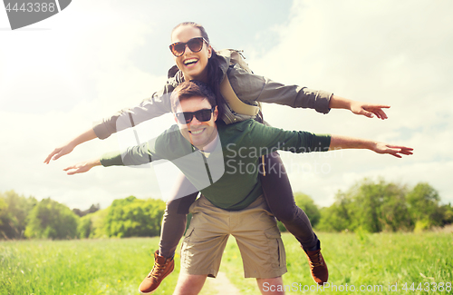 Image of happy couple with backpacks having fun outdoors