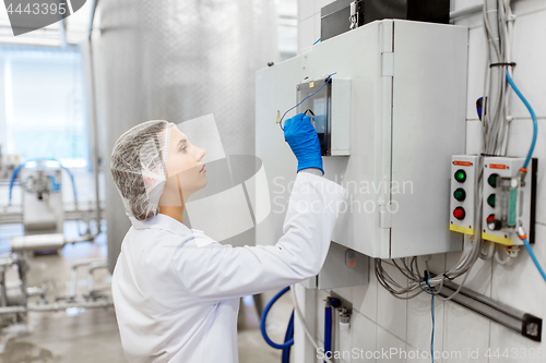 Image of woman programming computer at ice cream factory