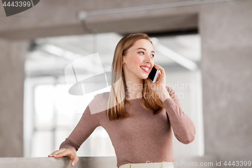 Image of businesswoman calling on smartphone at office