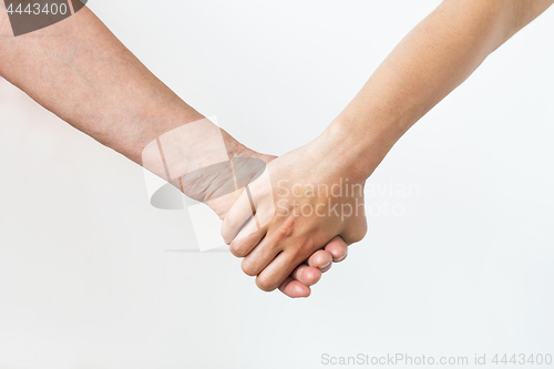 Image of close up of senior and young woman holding hands