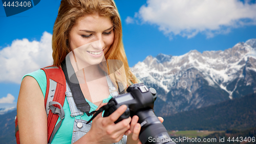 Image of woman with backpack and camera over alps mountains