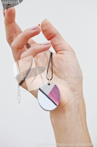 Image of Hand holding stylish necklace.