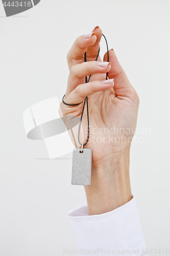 Image of Hand holding stylish necklace.