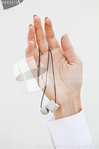 Image of Hand holding stylish necklace.