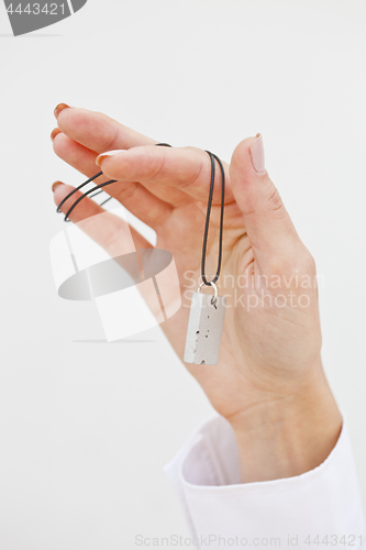 Image of Hand holding stylish necklace.