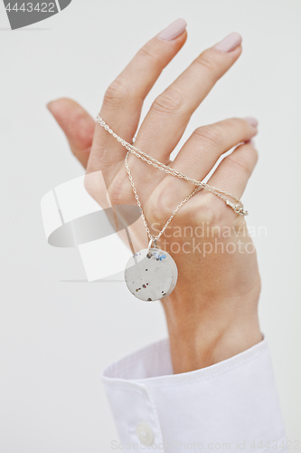 Image of Hand holding stylish necklace.
