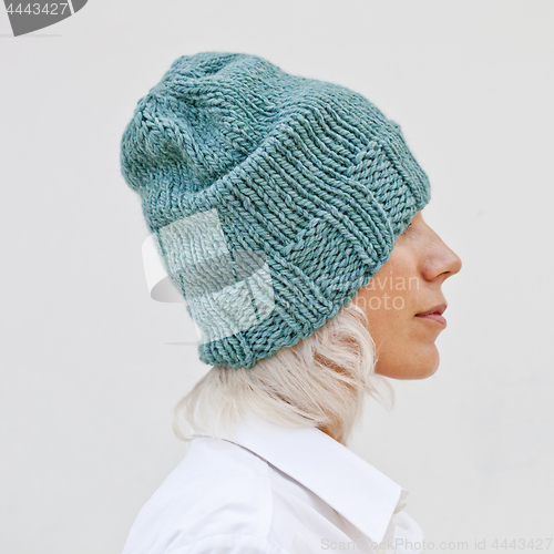 Image of Pretty woman in warm turquoise beanie wool hat.
