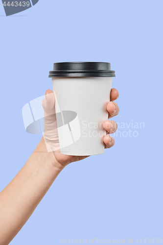 Image of Mockup of men\'s hand holding white paper mid size cup with black cover