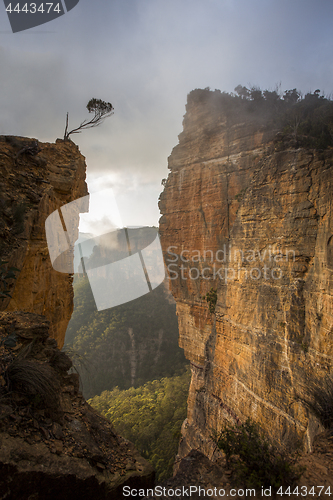 Image of Sunlight streaming through fog cloud lifting out of the valley