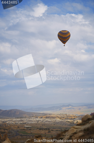 Image of Hot air balloon flying over the rocky land