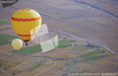 Image of Two air balloons flying over the land