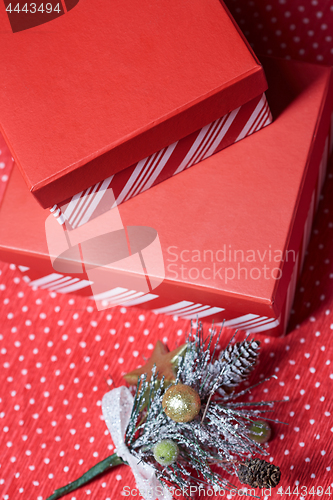 Image of Christmas gift boxes and twig of Christmas tree on a red wrappin