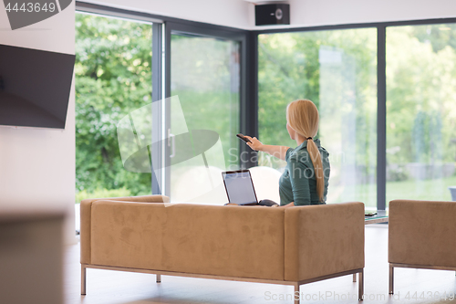 Image of Young woman using laptop at home
