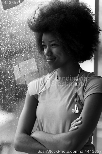 Image of portrait of young afro american woman in gym while listening mus