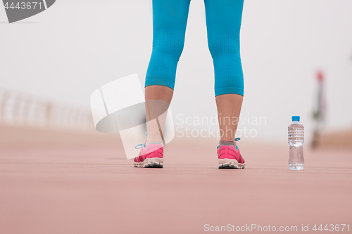 Image of close up on running shoes and bottle of water