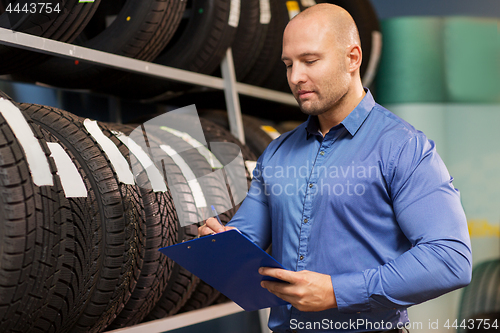 Image of auto business owner and wheel tires at car service