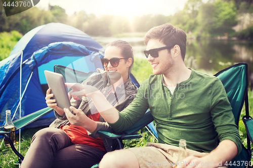 Image of happy couple with tablet pc at camping tent