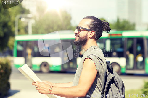 Image of man traveling with backpack and map in city