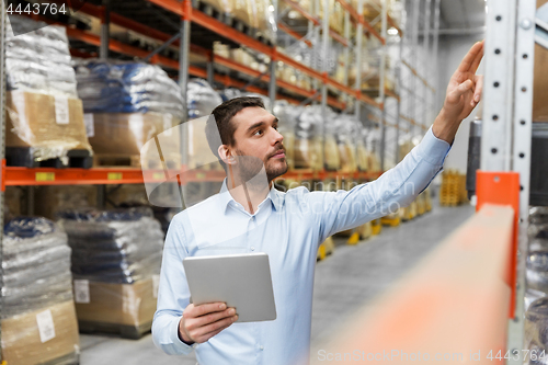 Image of businessman with tablet pc at warehouse