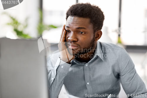 Image of stressed businessman with computer at office