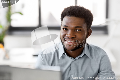 Image of african american businessman with laptop at office